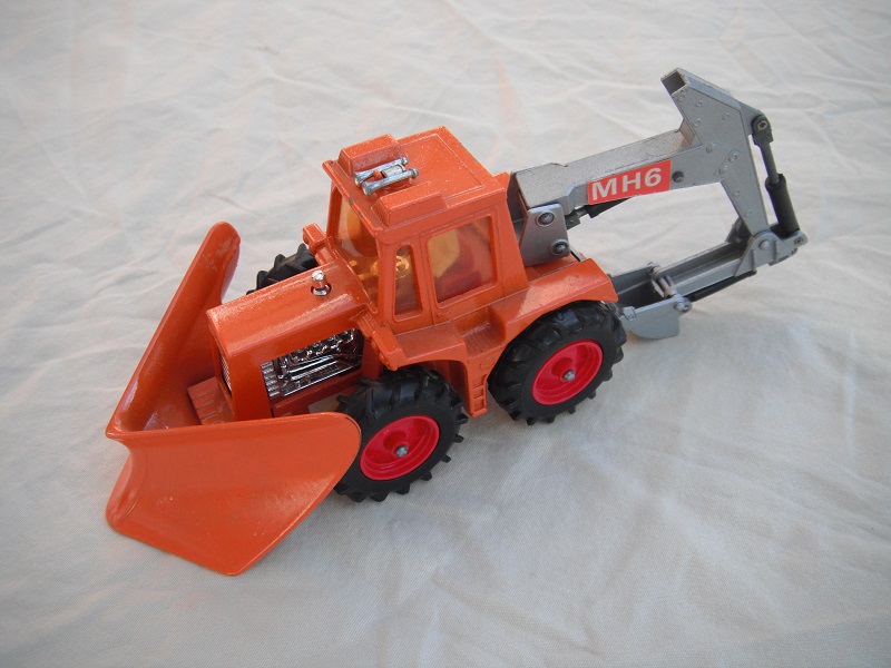 9. Orange tractor/org plow/sil backhoe &amp; scoop/lt.amb wind/thick tires/dk.red hubs/dk.red int/1972 England cast/sil plate above tow hook/MH6 lbls.