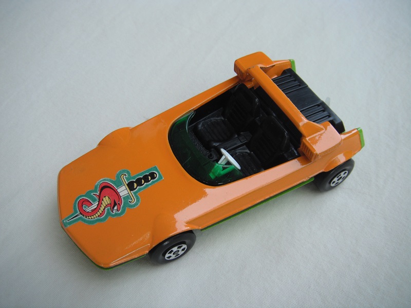 6. Orange body/lime green base/Speedkings/grn windshield/orange cast headlights/wht steering wheel/translucent white tow hook/sword &amp; snake label.