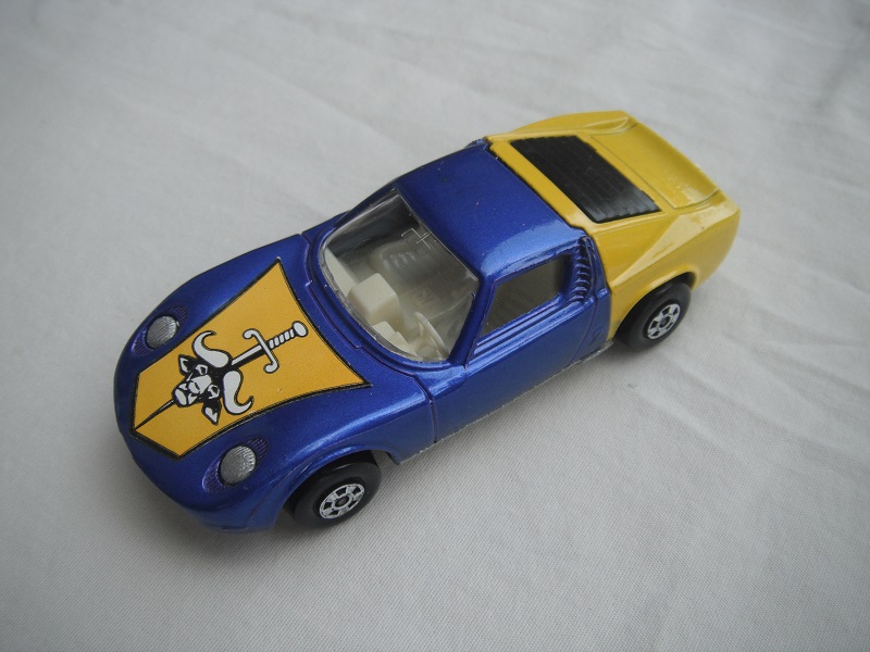 25.Blu/yel body/unpainted base/5 spoke wheels/clear windows/white int/unpainted headlights/hood label/white tow hook.