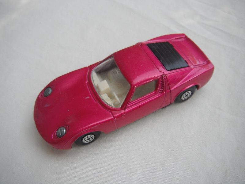 13.Burgundy body/unpainted base/spiro wheels/clear windows/white int/unpainted headlights/no hood label/white tow hook.