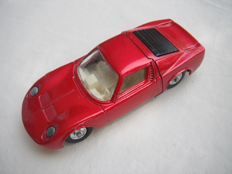 3. Met.red body/unpainted base/BPT w/5 spoke hubs/clr windows/white int/unpainted headlights/cast license plate/no tow hook/Err.right front whl.