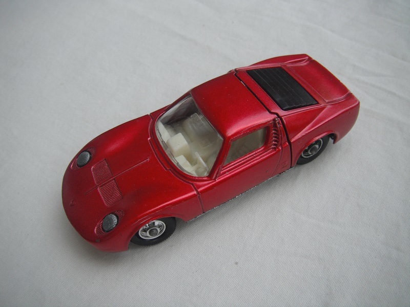 2. Met.red body/unpainted base/BPT w/5 spoke hubs/clr windows/white int/unpainted headlights/cast license plate/no tow hook.