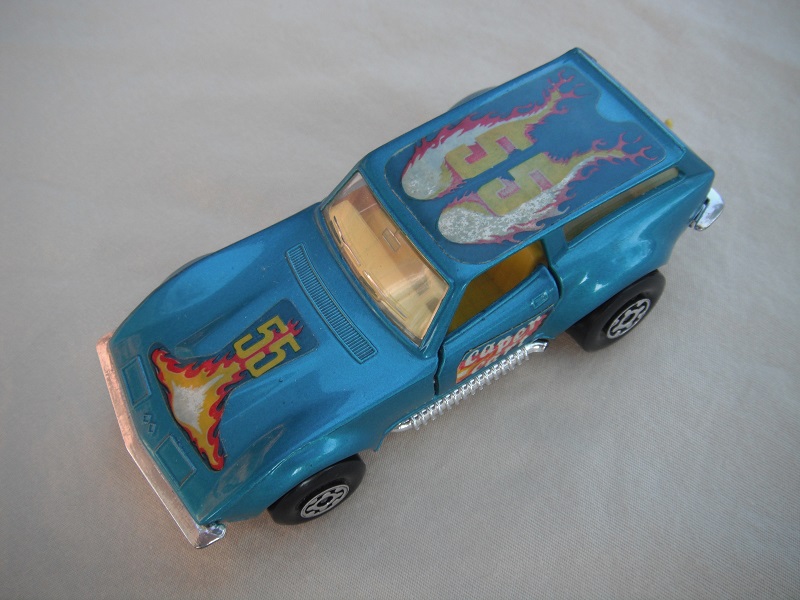 12.Lt.metallic blue body/silver base/Speedkings/MC wheels/clear windows/yellow interior/caper cart on doors/&quot;55&quot; in yellow/flames on hood &amp; roof.