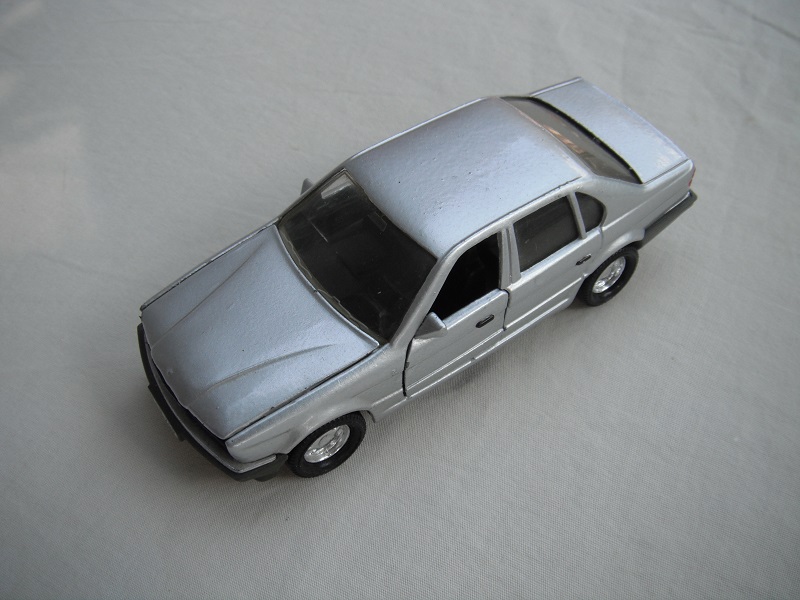 9. Silver body/gray China base/chrome 8 dot disc wheels/clear windows/black interior/white rear license plate.