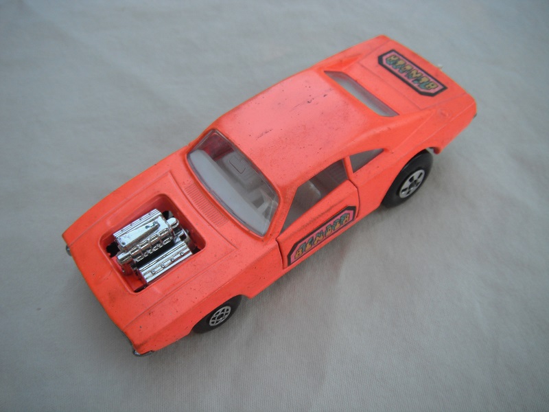 7. Orange-pink body/unpainted base/clear windows/spiro &amp; five spoke wheels/&quot;Binder&quot; labels on side doors &amp; rear.