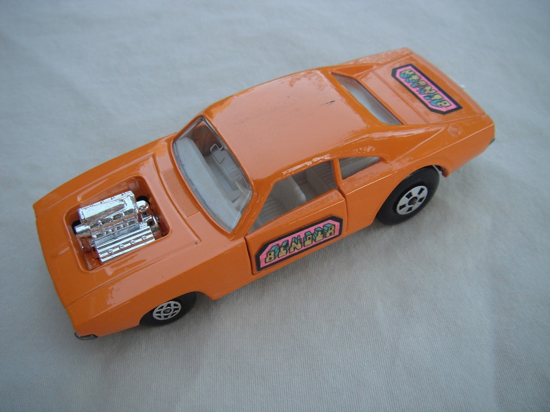 2. Orange body/unpainted base/clear windows/spiro &amp; five spoke wheels/&quot;Binder&quot; labels on side doors &amp; rear.