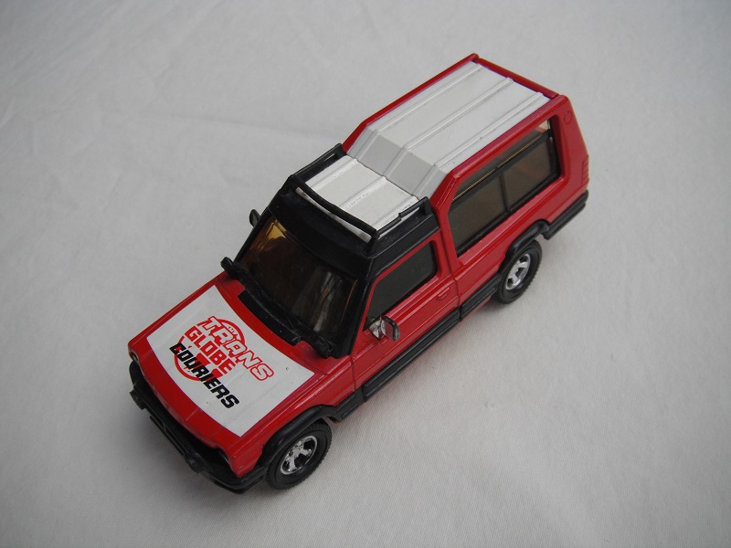 6. Red body/white roof/red metal base/England/amber windshield/amber windows/black interior/&quot;Trans Globe Couriers&quot; on hood.