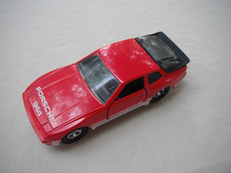 16.Dk.red body/blk base/Macau/5SM whls/clr windows/clr rear/blk int/blk steering/Porsche 944 on hood/Porsche &amp; white stripes on side.