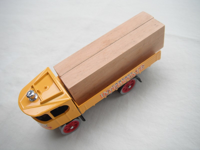 3. Yellow cab/long yellow bed/black base/red wheels/load of timber.