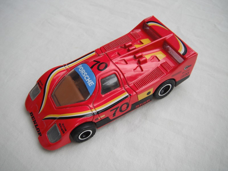 19.Red body/black base/Macau/clear windows/brown interior/unchromed wheels/pullback motor/Porsche Dunlop #70.
