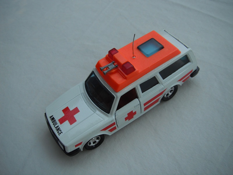 4. White body/orange plastic roof cover/black base/5SMW/blue windows/no trim/orange interior/red dome lts/lrg red cross/stripes.