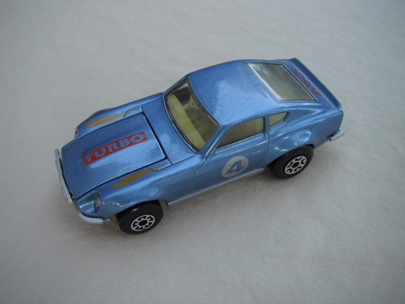 B139. Metallic blue body/silver base/light yellow interior/5 arch front, 5 crown rear wheels/ &quot;4&quot; on door.