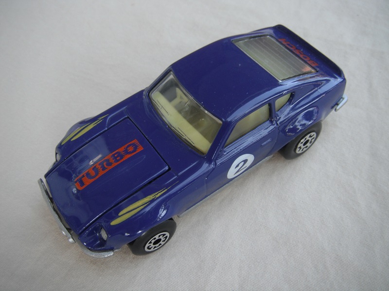 B128. Purple body/silver base/light yellow interior/5 arch front, 5 crown rear wheels/&quot;2&quot; on door &amp; Turbo on hood.