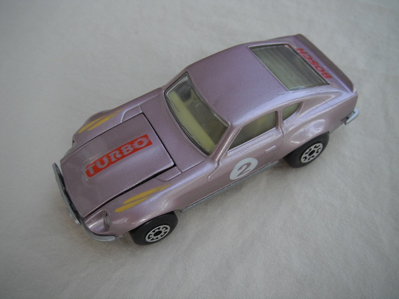 B122. Mauve body/silver base/black interior/5 arch front, 5 crown rear wheels/&quot;2&quot; on door &amp; Turbo on hood.