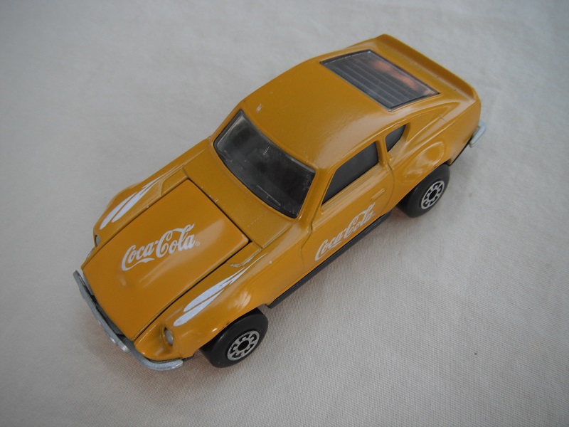 B109. Mustard yellow body/charcoal base/black interior/5 arch wheels(small)/Coca Cola decals.