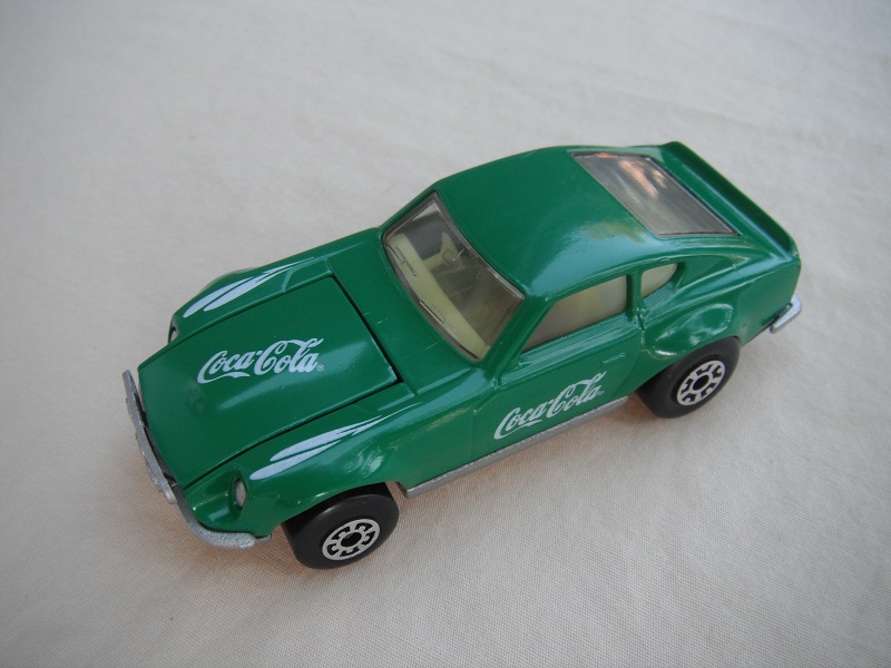 B105. Green body/charcoal base/light yellow interior/5 arch front, 5 crown rear wheels(large)/Coca Cola decals.