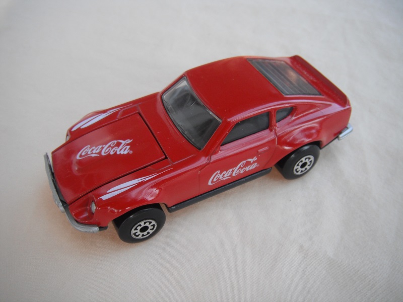 B103. Red body/charcoal base/black interior/5 arch wheels/Coca Cola decals.