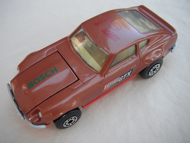 B60. Metallic brown body/red base/light yellow interior/5 arch front, 5 crown rear wheels/Castrol/GTX decals.