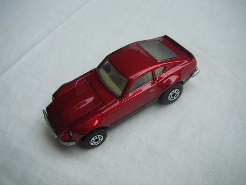 B25. Metallic dark pink body/charcoal base/light yellow interior/5 crown front, 5 arch rear wheels.