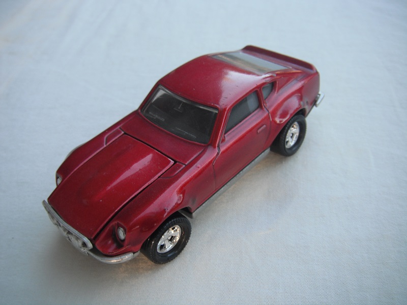 B7. Metallic dark pink body/silver base/black interior/5 spoke mag wheels.
