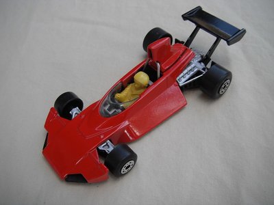 B2. Red body/gloss black base/dot-dash front, large 5 crown rear wheels/black airfoil/lt.yellow driver.