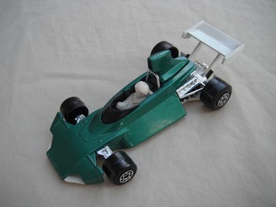 E3. Met. dk.grn body/white base/narrow rear whls/white airfoil/white driver w/ large white helmet.